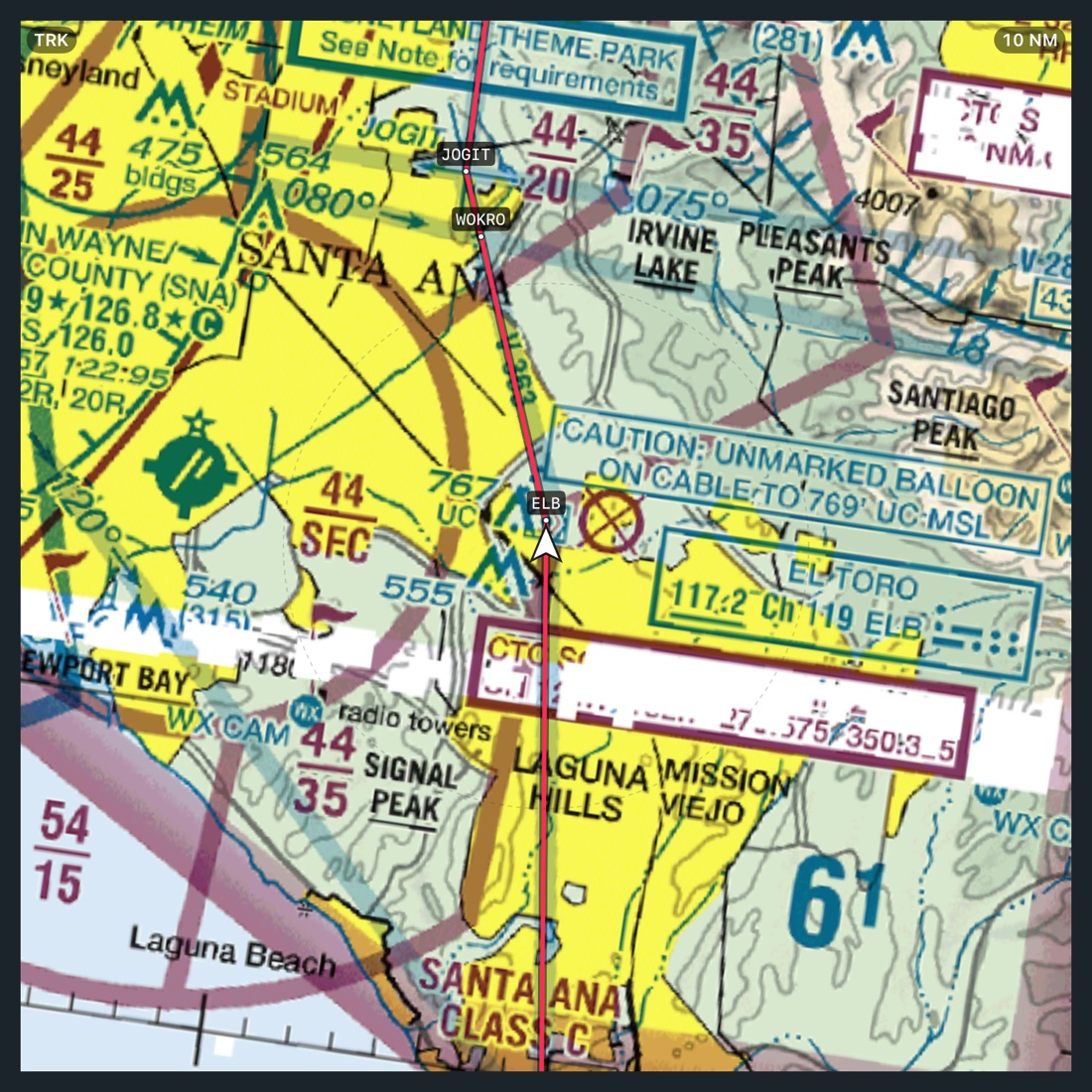 The moving map on the VFR layer at 10 NM over Santa Ana and El Toro, track-up, the magenta route running through JOGIT, WOKRO and ELB with each fix labelled and the white ownship at centre.
