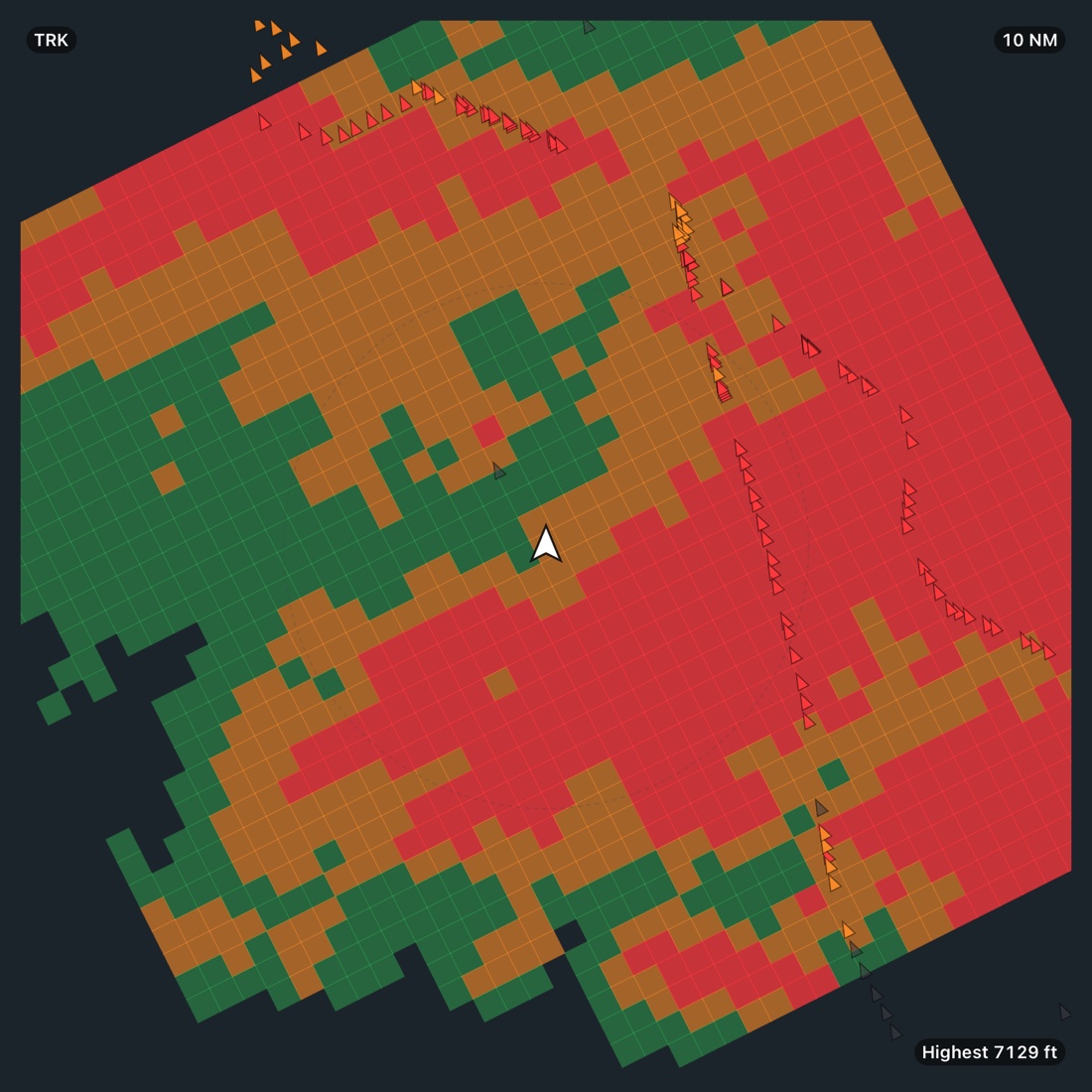 The moving map on the terrain layer crossing the San Gabriel Mountains at 10 NM range: terrain at or above the aircraft in red, close below in amber, clear in green, with ridge-line towers marked and Highest 7129 ft in the corner.